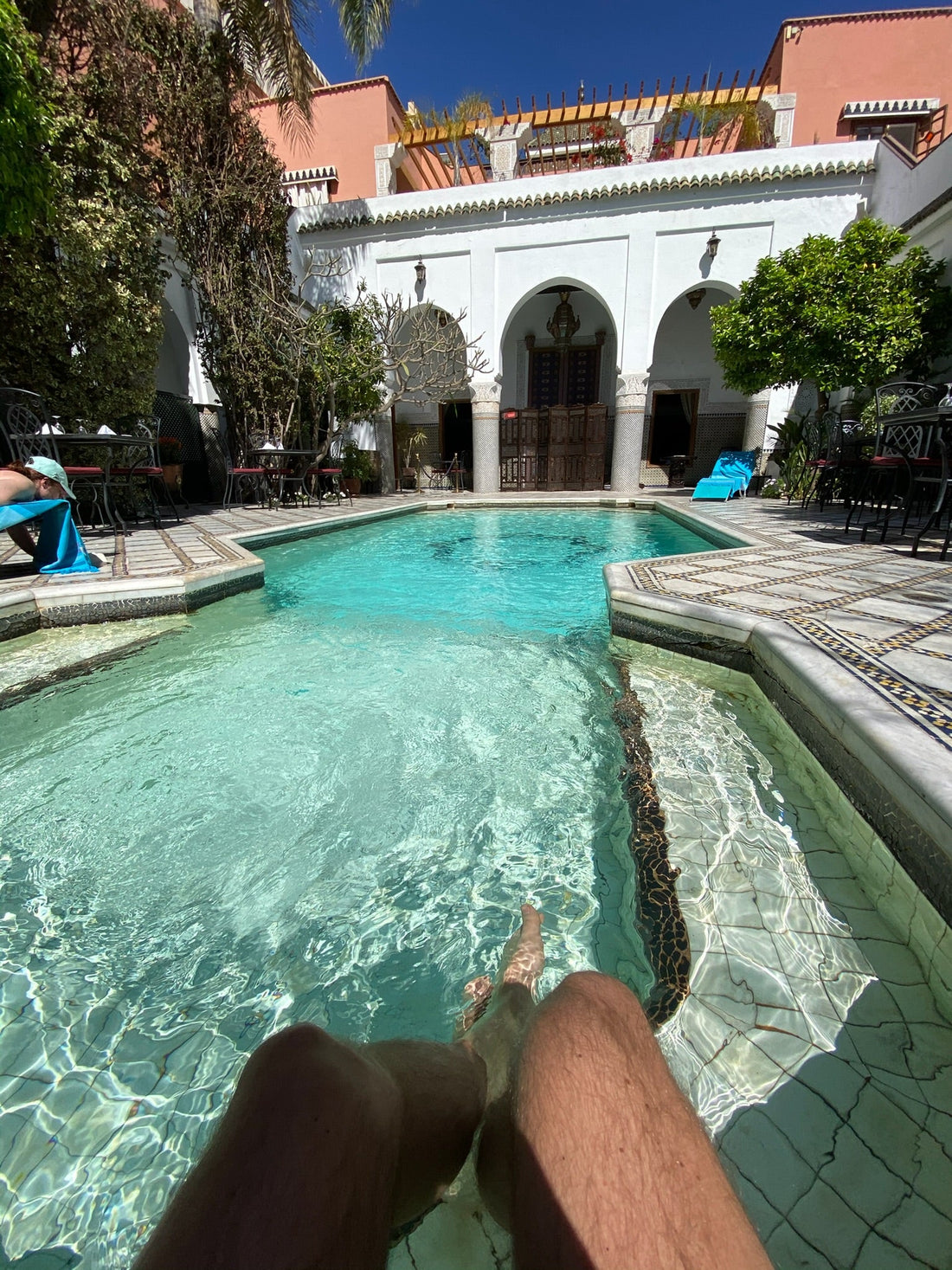 Quiet riad pool in Marrakesh framed by white arches