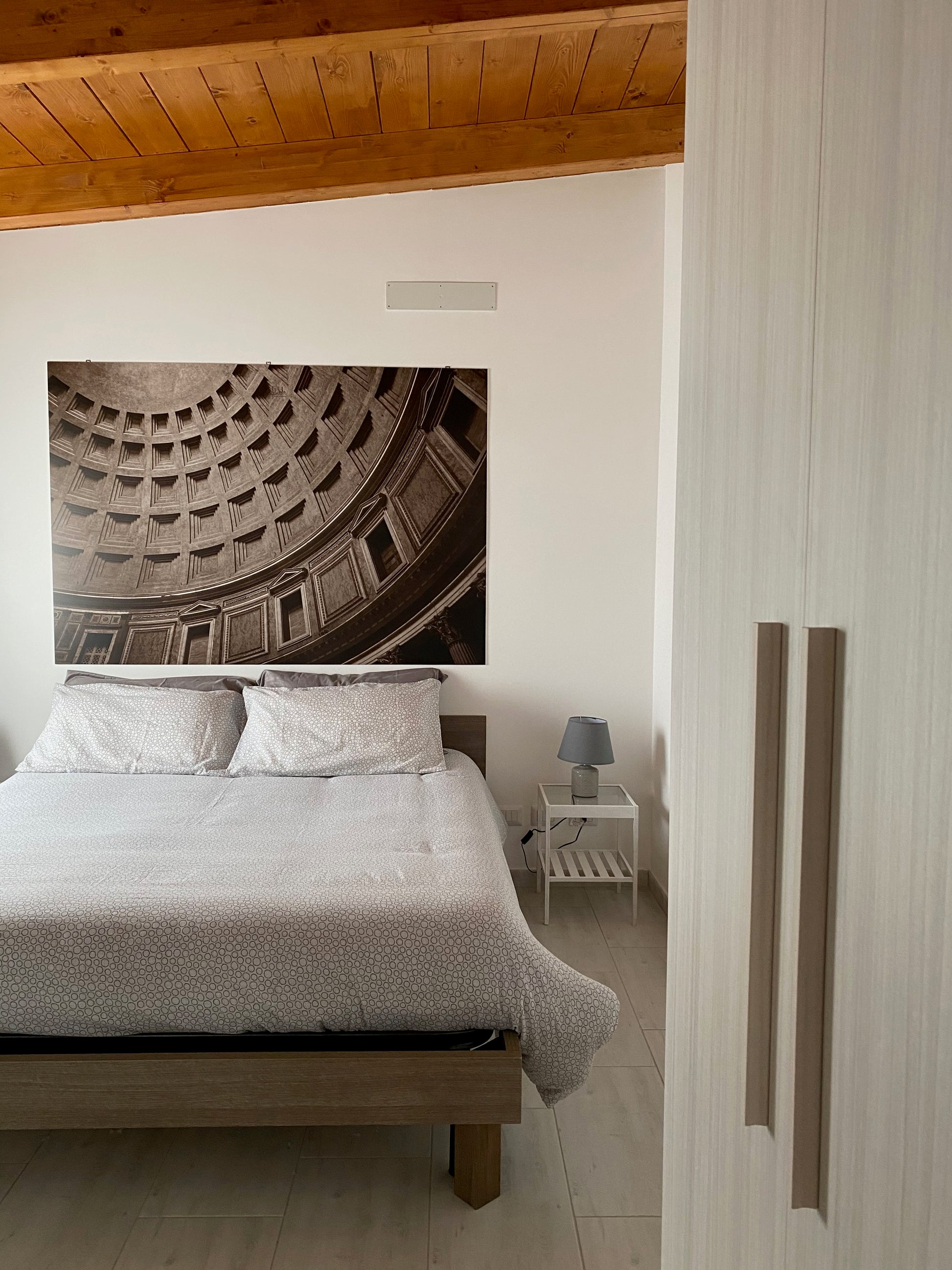 Modern bedroom with a large wall art piece of a architectural design.